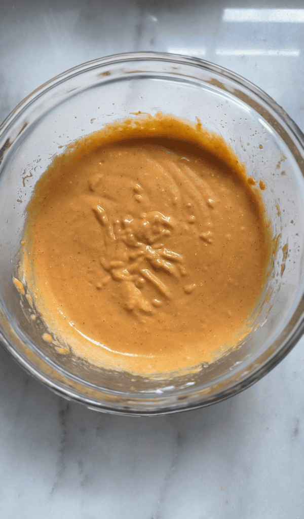 All the mixed wet ingredients for the pumpkin cottage cheese muffins in one bowl.
