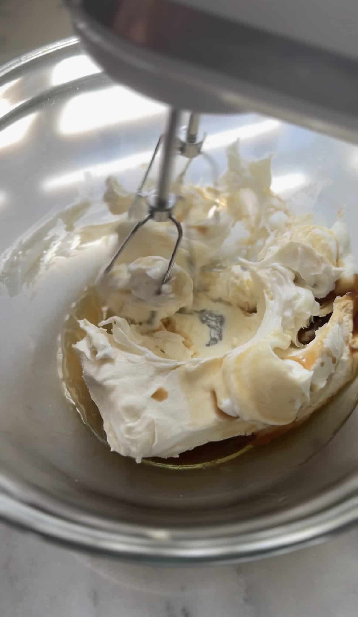 Mix the cream cheese frosting into the bowl with a hand mixer.