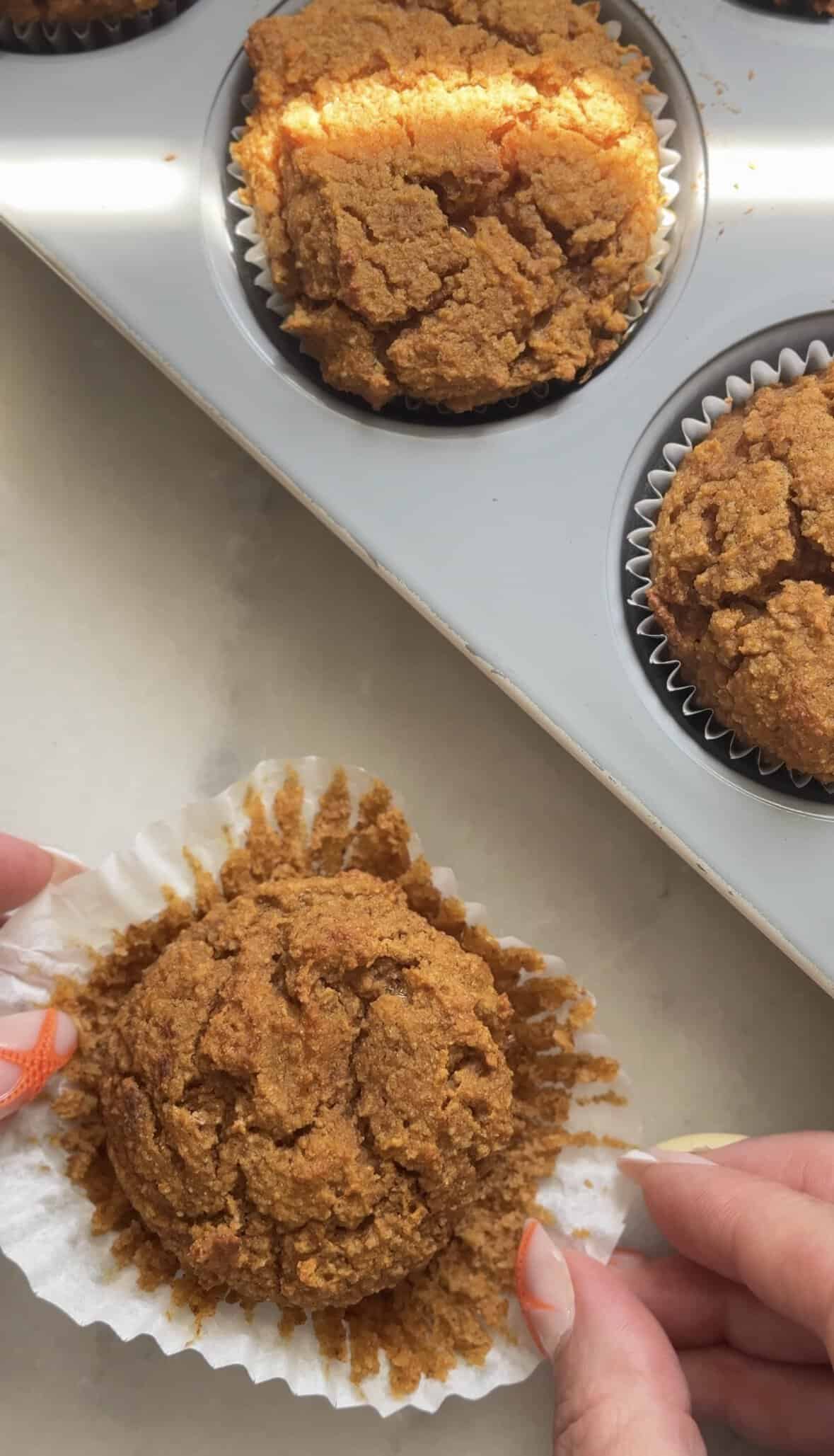 Finished pumpkin cottage cheese muffin in the liner being removed.