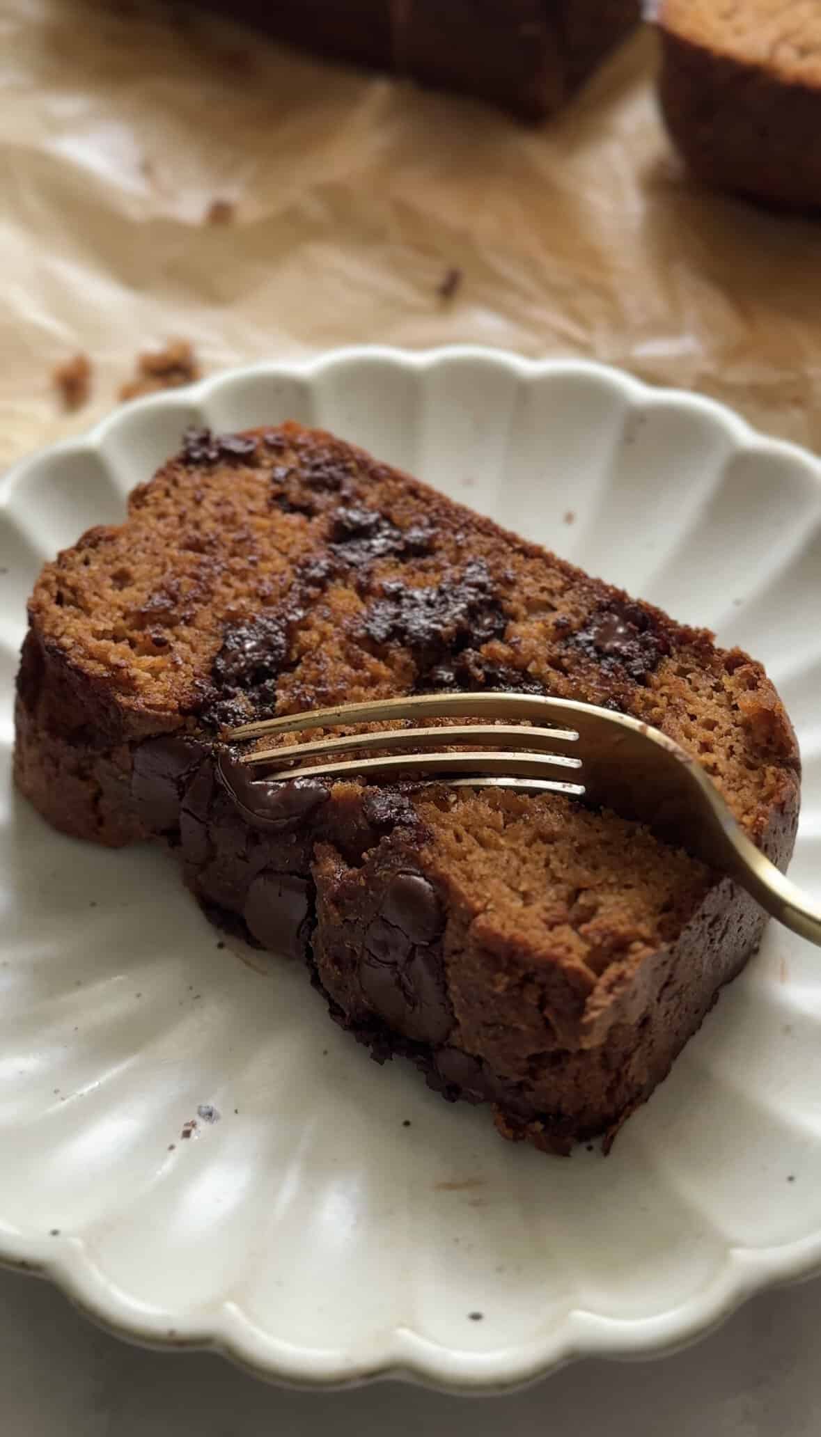 Gluten Free Protein Pumpkin Bread on a plate with a fork taking a bit of the slice.