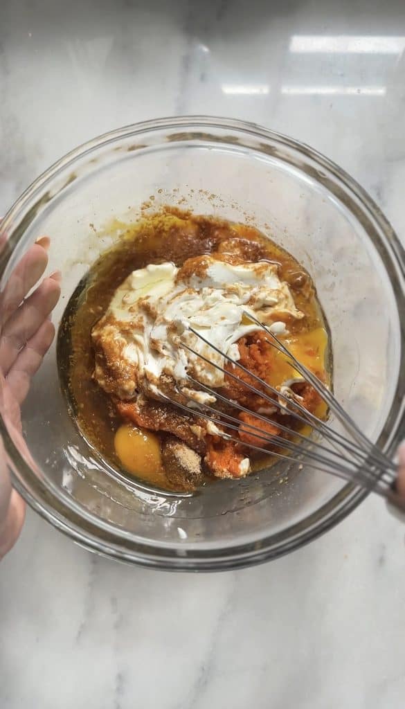 Mixing all the wet ingredients for the pumpkin cottage cheese muffins into one bowl.