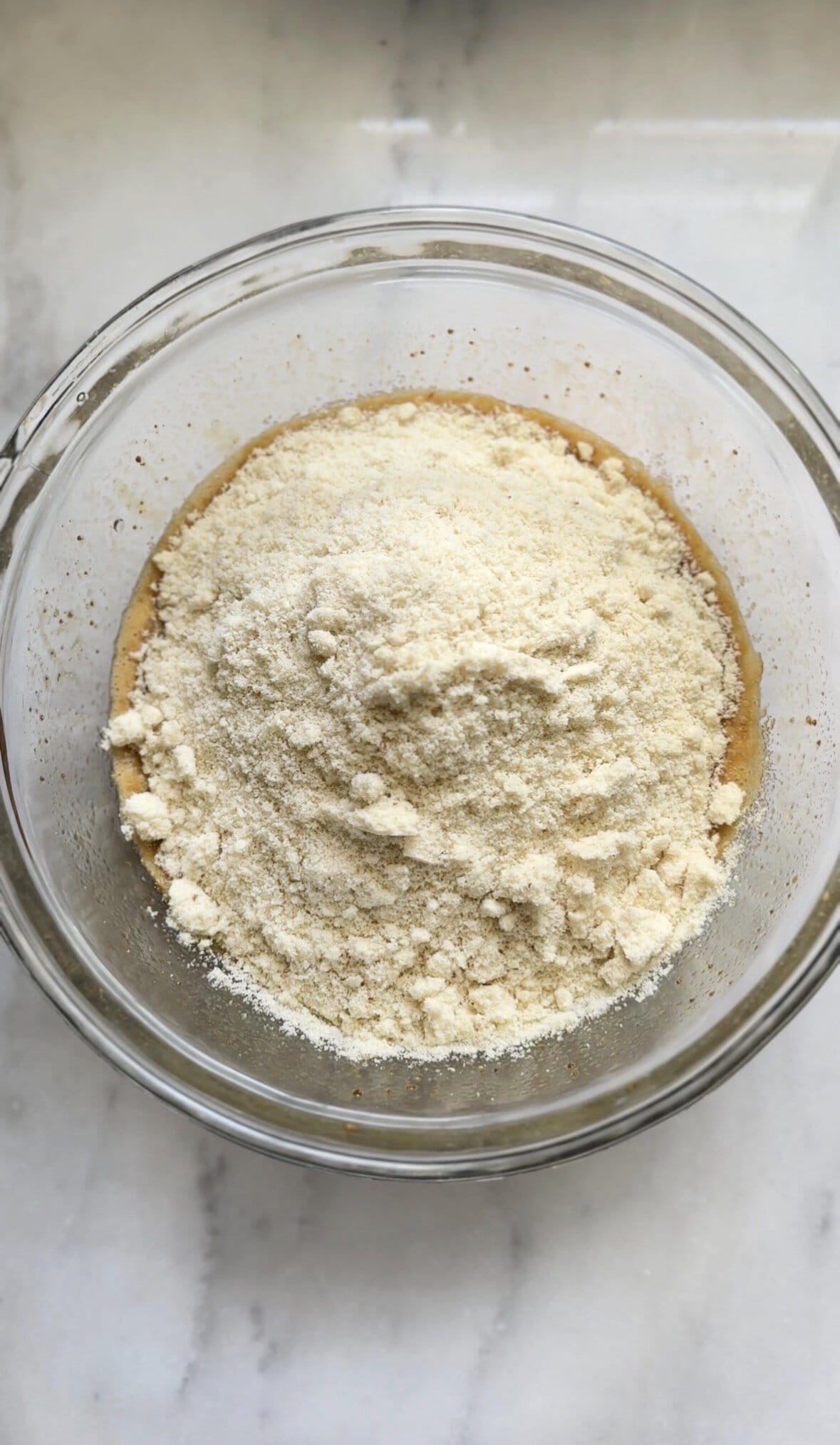 Add the dry ingredients of the banana donuts into the same bowl as the wet ingredients.