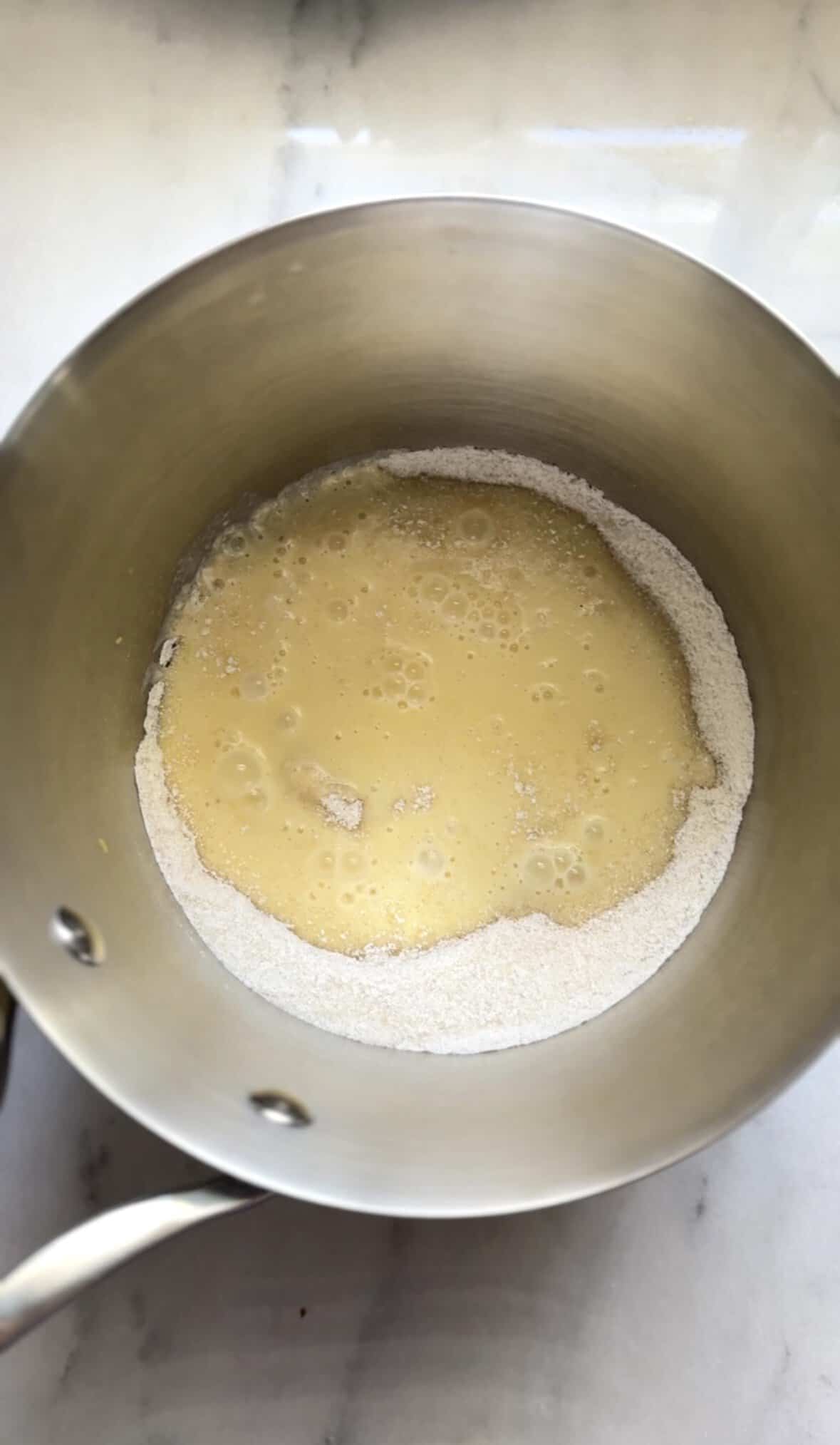 Add the banana milk to the dry ingredients of the banana frosting into a saucepan.