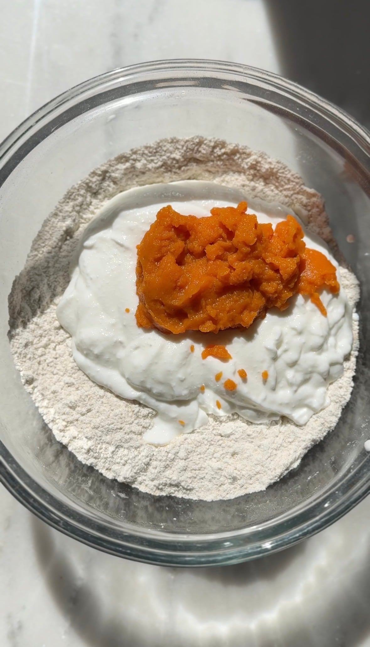 Add the pumpkin puree to the bowl to make the pumpkin cottage cheese cinnamon roll dough.