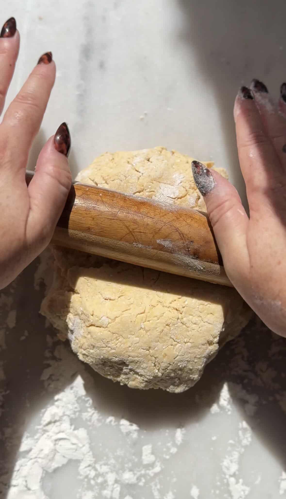 Roll out the pumpkin cottage cheese cinnamon rolls on the counter with a rolling pin.