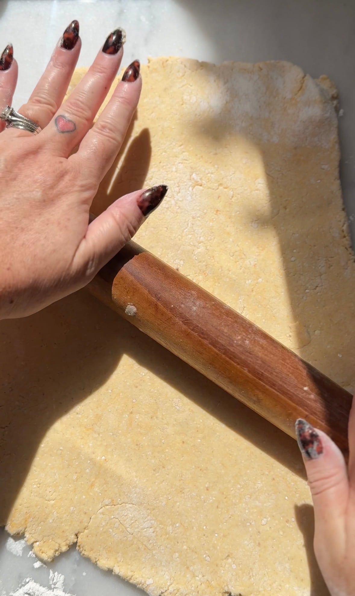 Continue to roll out the pumpkin cottage cheese cinnamon rolls on the counter with a rolling pin.
