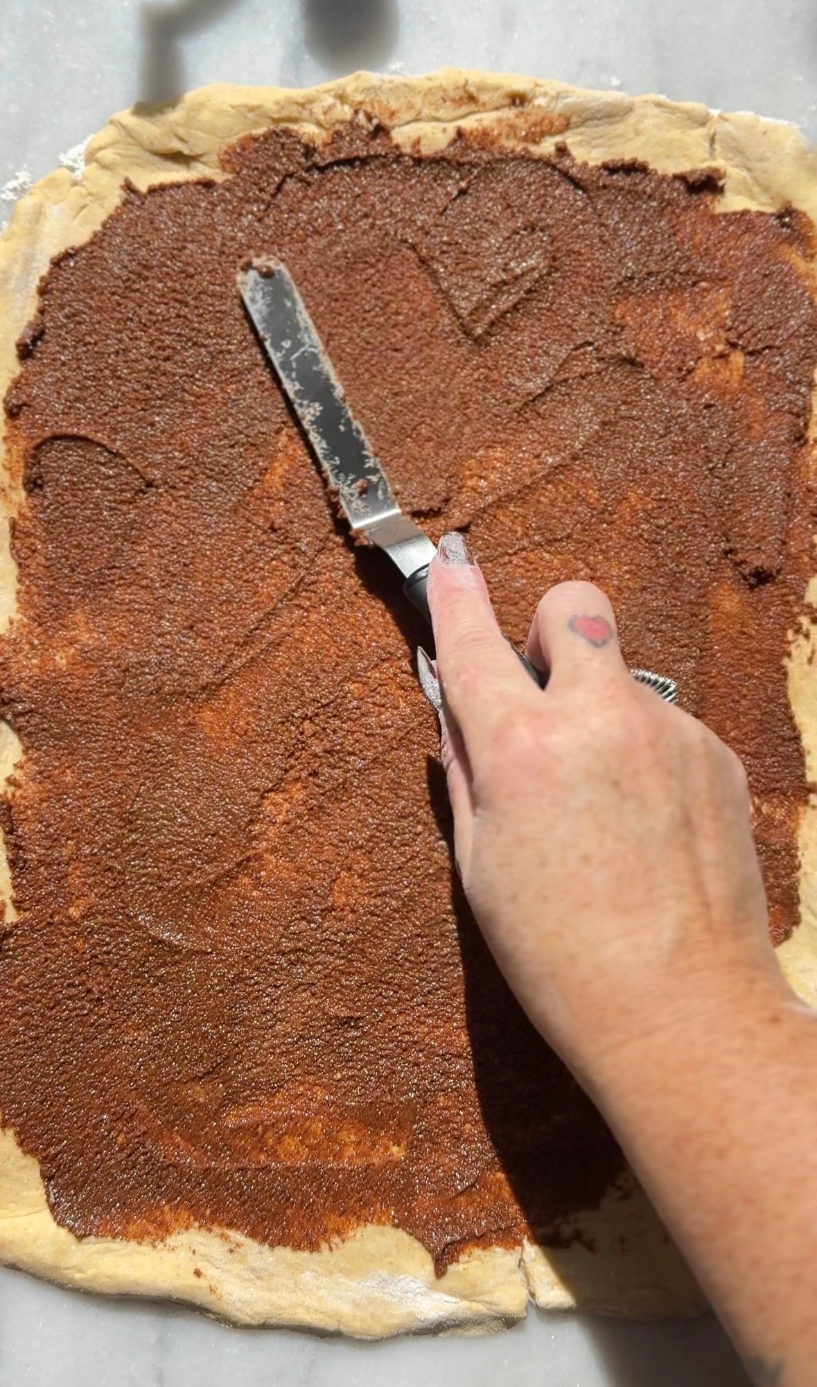 Spread the cinnamon roll filling onto the rolled out cinnamon roll dough.