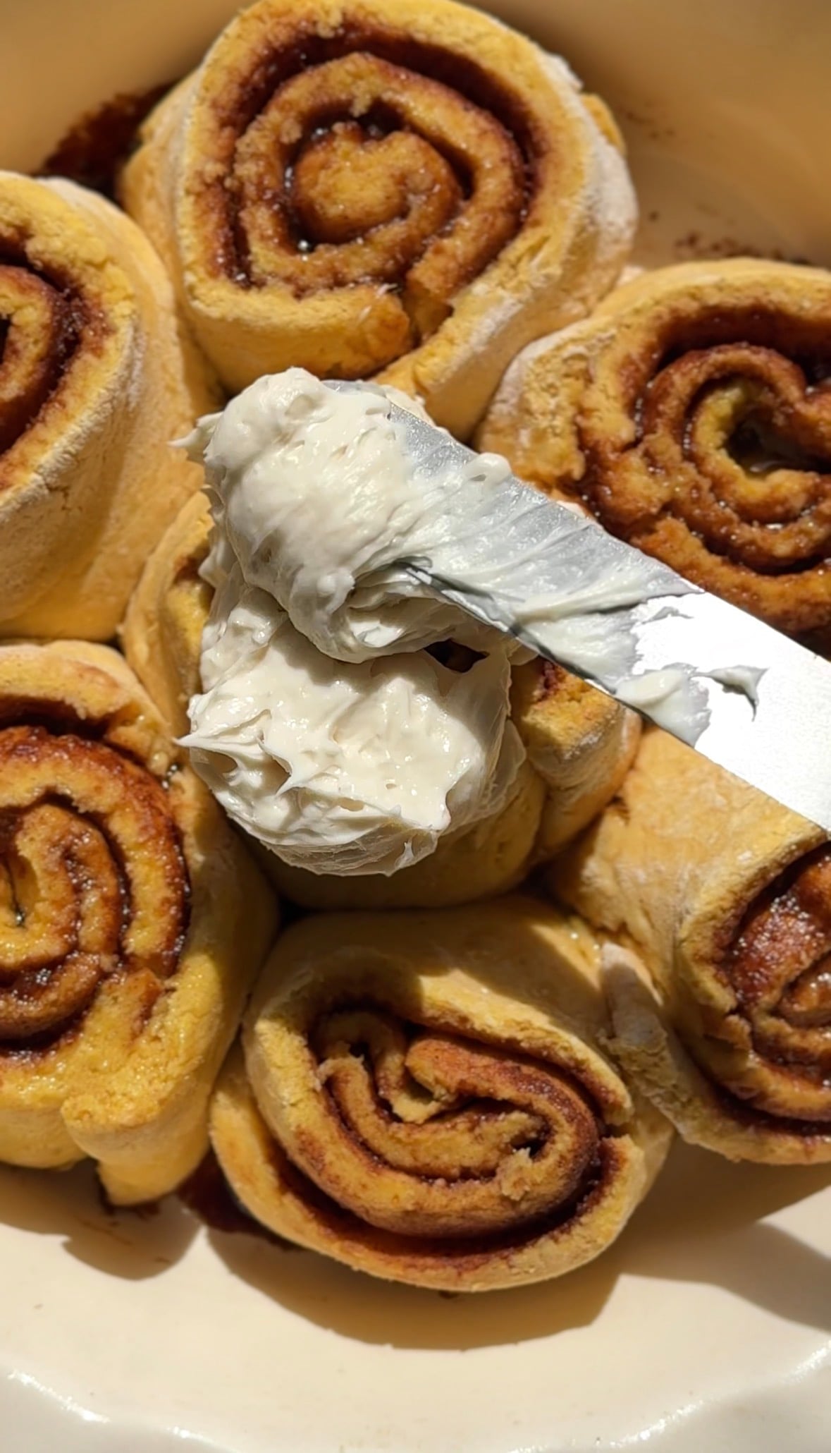 Add the cream cheese frosting to the top of the baked and cooled pumpkin cottage cheese cinnamon rolls.