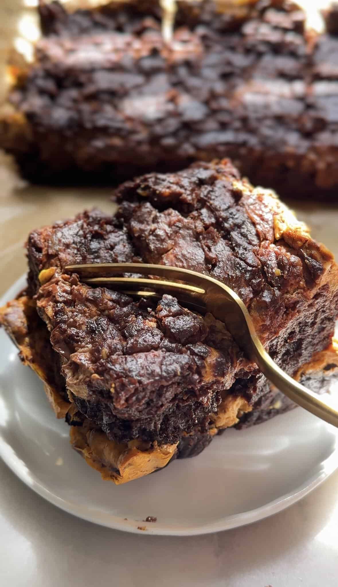 Pumpkin Brownie square on a plate with a fork taking a chunk off to be eaten.