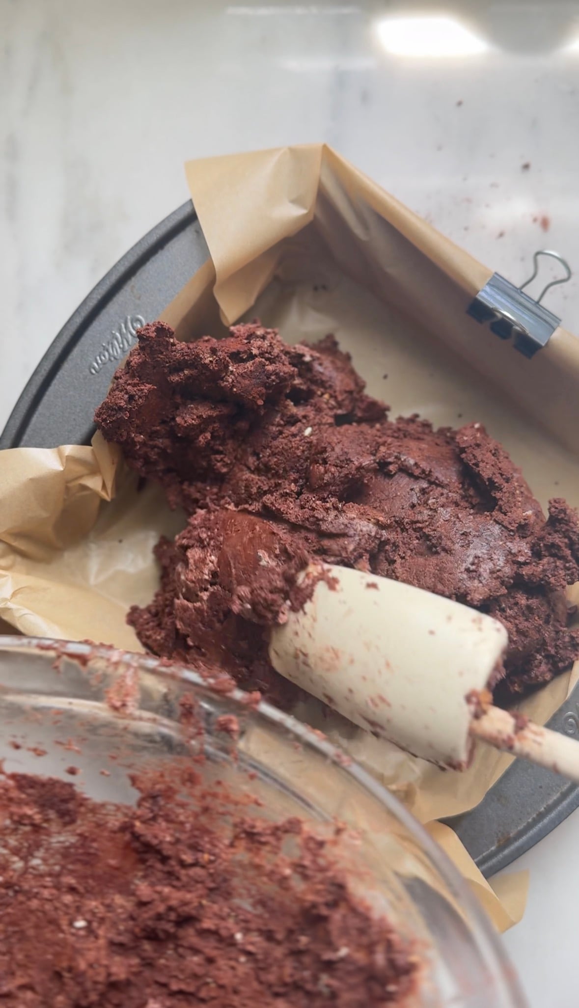 Scoop the brownie base into a parchment paper-lined 8x8" cake pan.