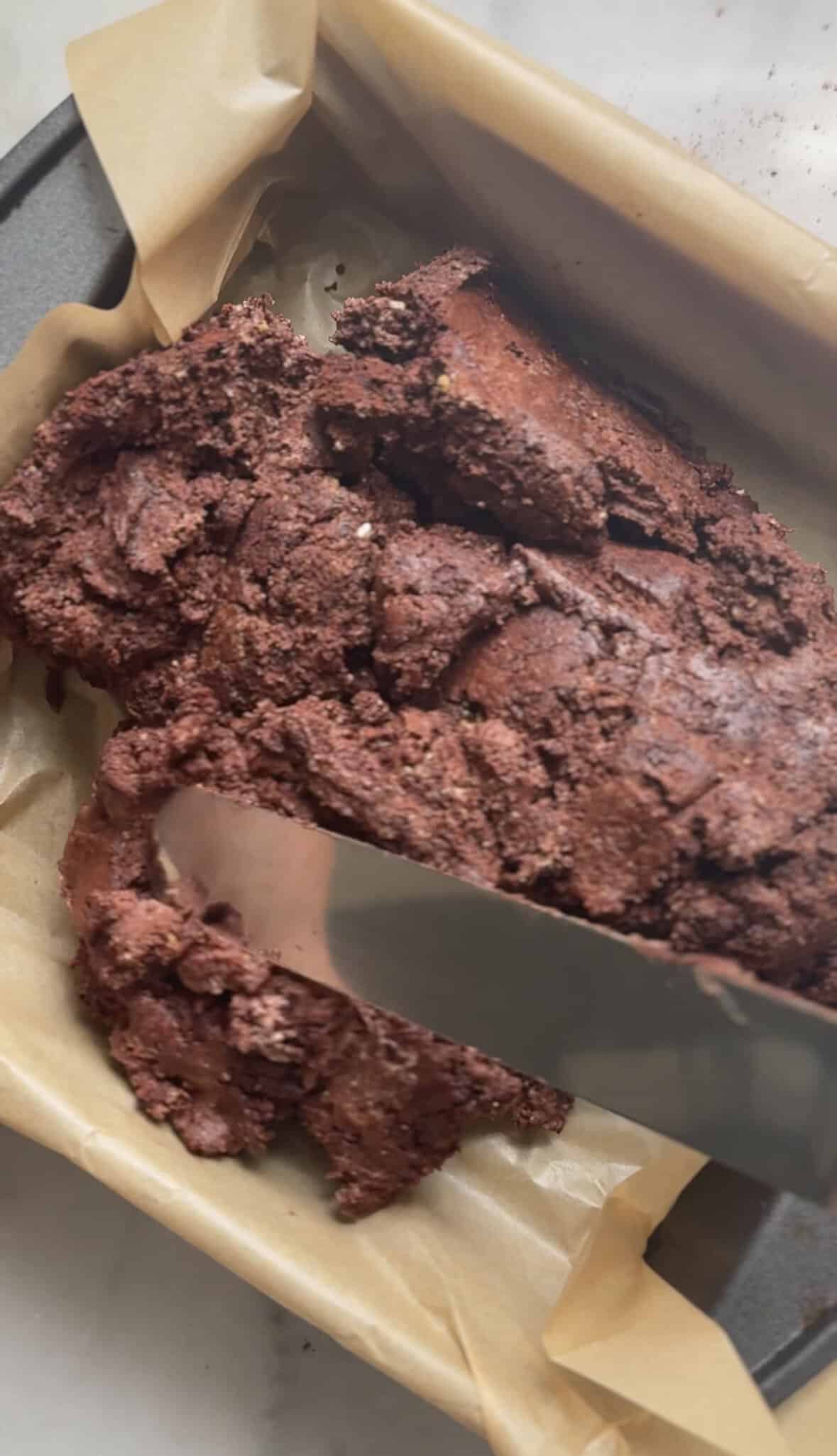 Level the brownie base into a parchment paper-lined 8x8" cake pan.