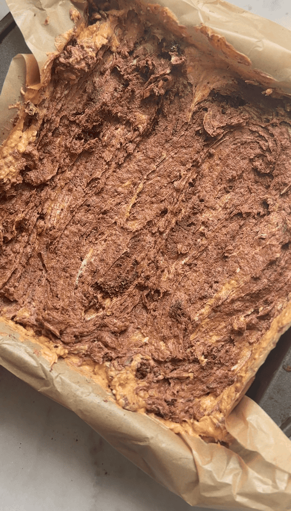 Swirl the pumpkin cream cheese and brownie bases together in the cake pan before baking.