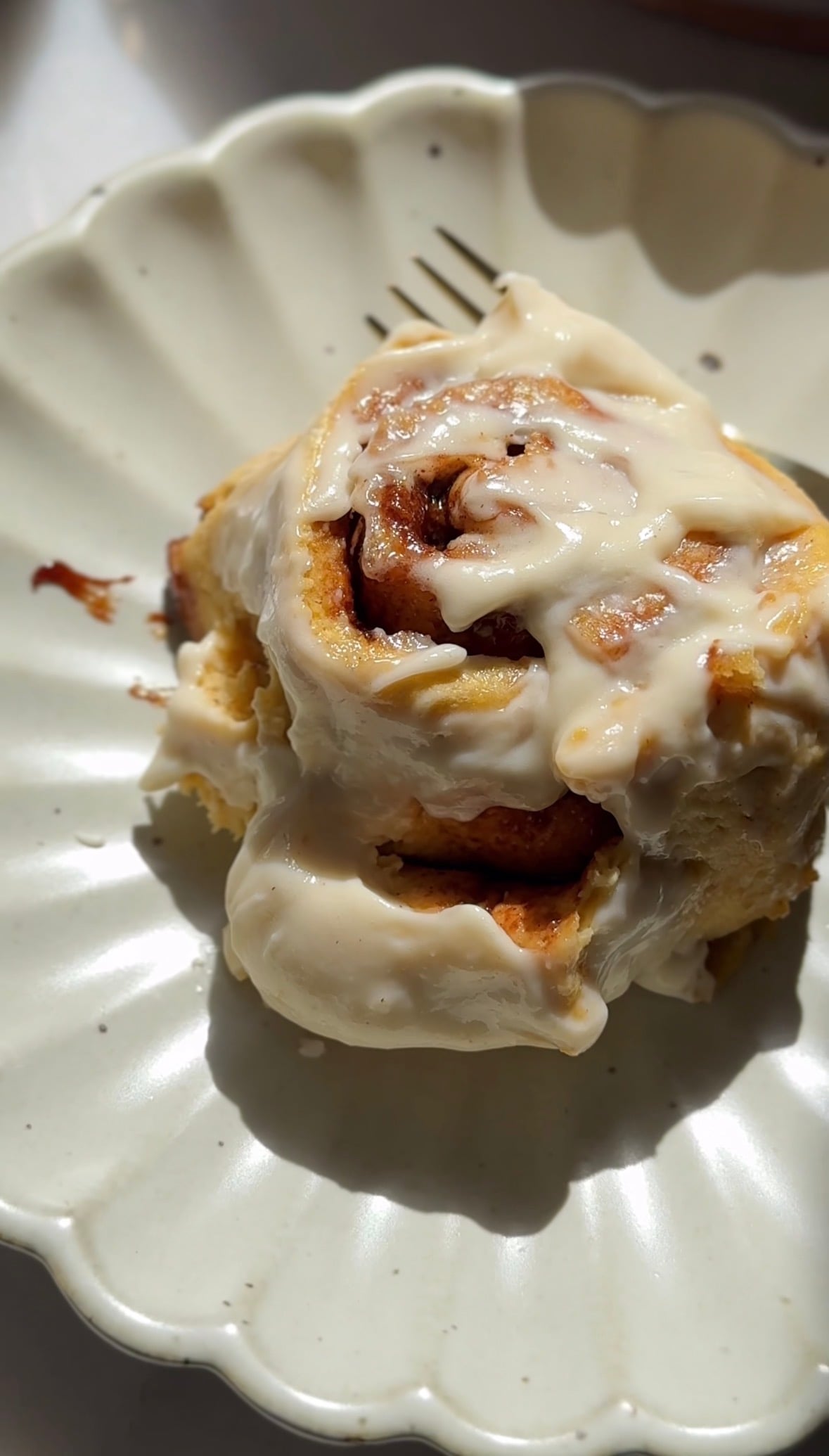 Close up of the glazed pumpkin cottage cheese cinnamon roll on a plate.