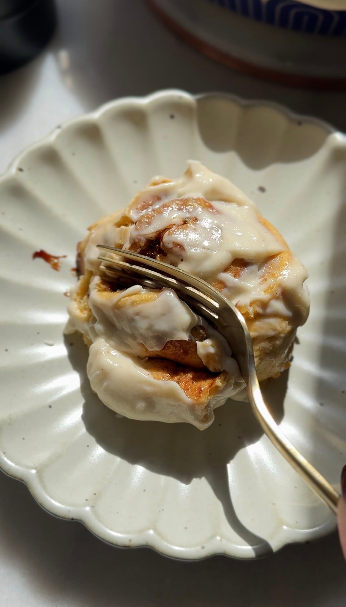 Close up of the glazed pumpkin cottage cheese cinnamon roll on a plate.