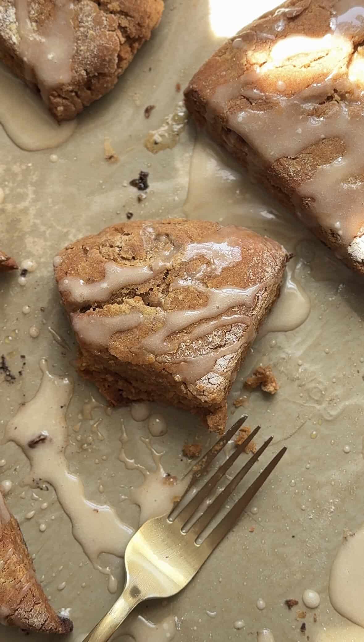 Half eaten Pumpkin Cottage Cheese Scone shown with a fork on a sheet pan.