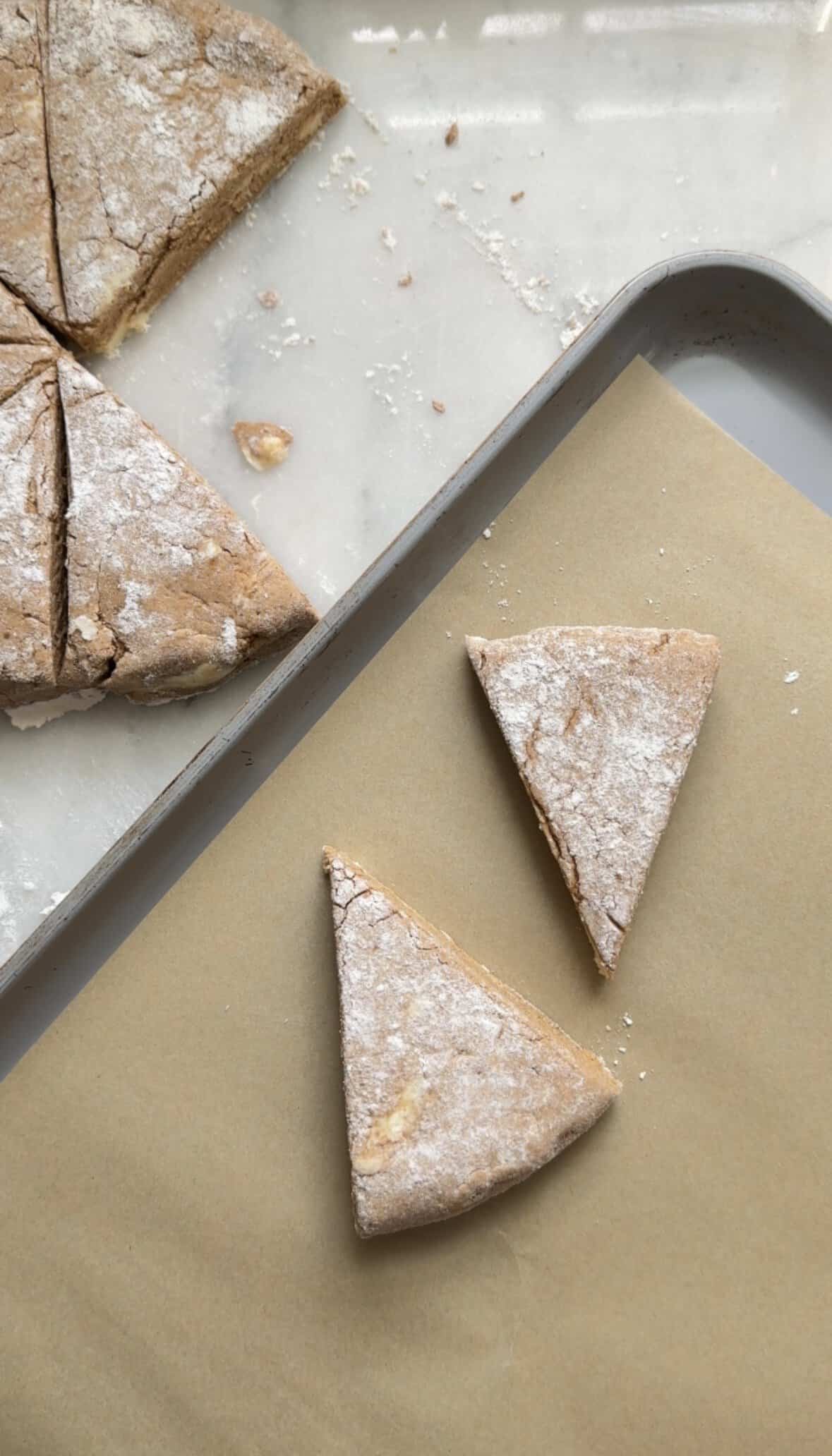 Putting the unbaked Pumpkin Cottage Cheese Scone wedges on a sheet pan lined with parchment paper.