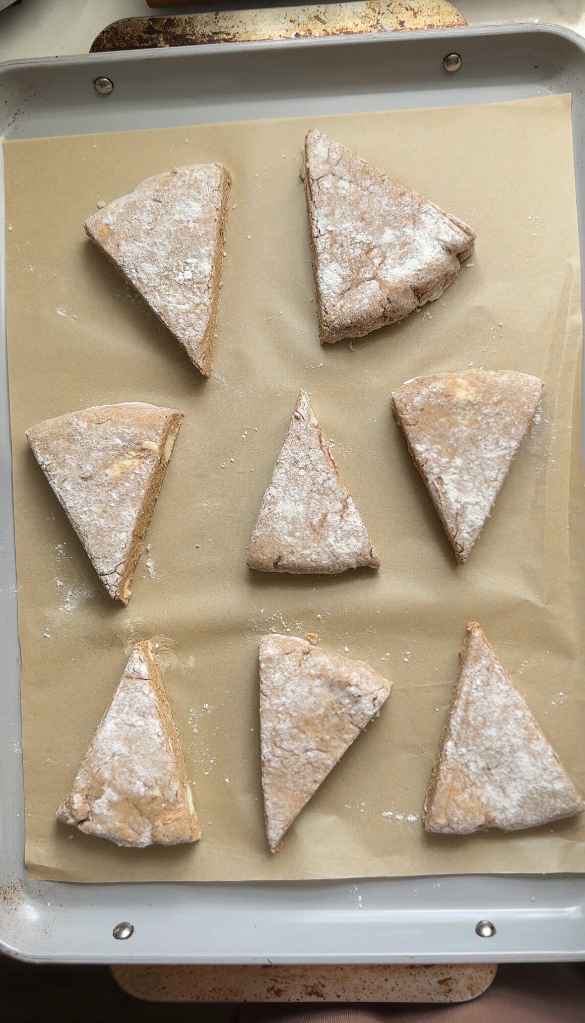 Unbaked Pumpkin Cottage Cheese Scones on a sheet pan with parchment paper.