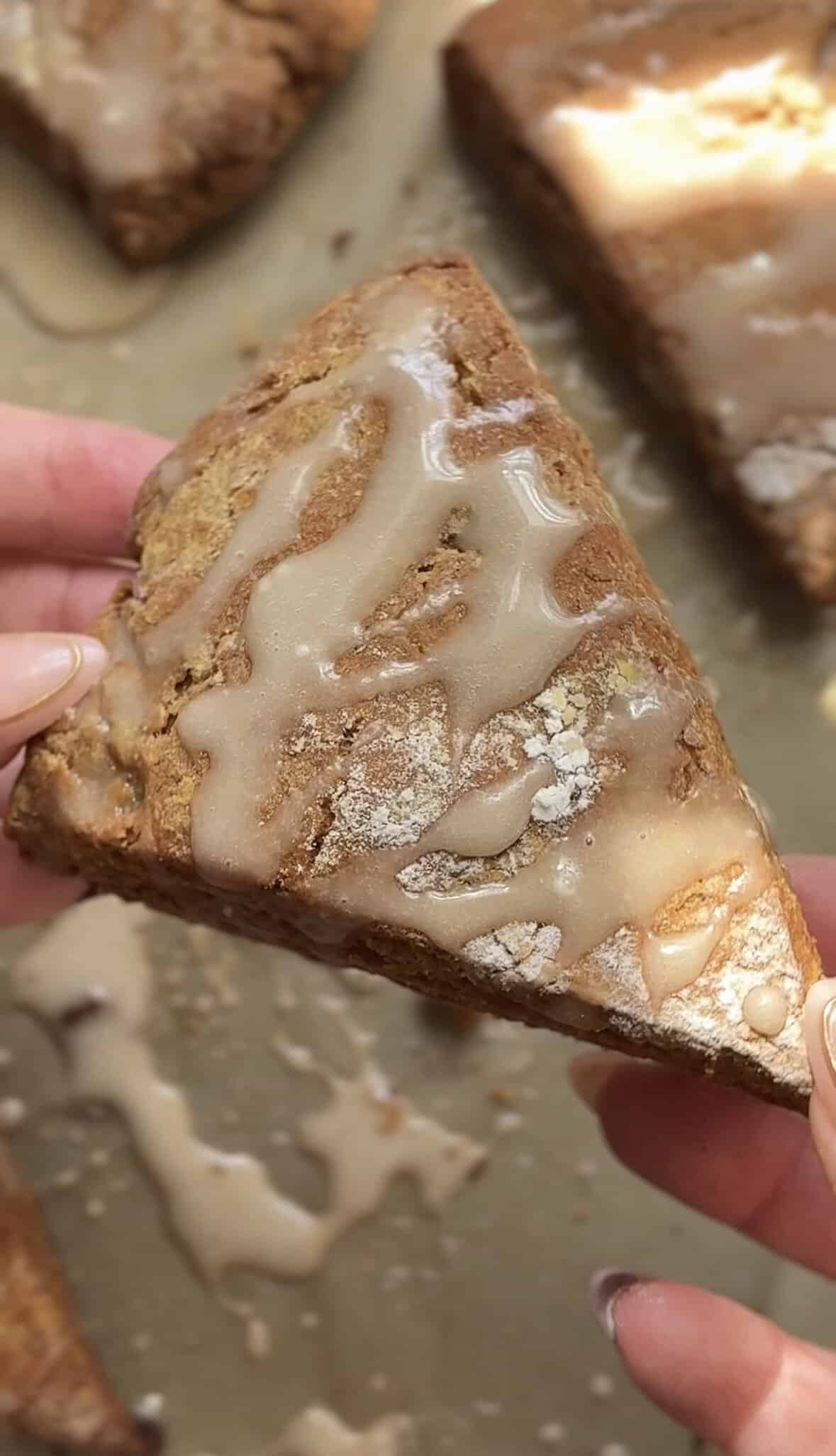 Holding a Pumpkin Cottage Cheese Scone up to the camera to show the texture and coloring of the outside of the scone.