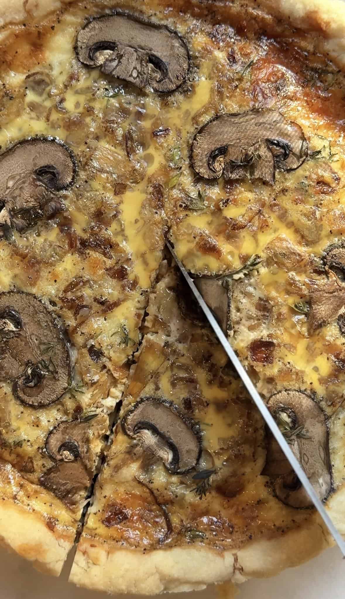 Slicing a piece of the Gluten Free Caramelized Onion Quiche in the pie tin.