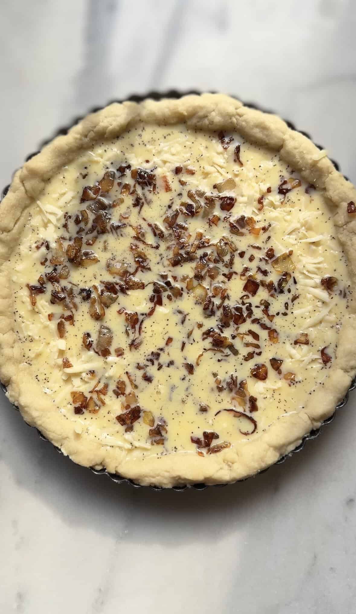Add the caramelized onion mixture to the egg custard in the par-baked pie crust.