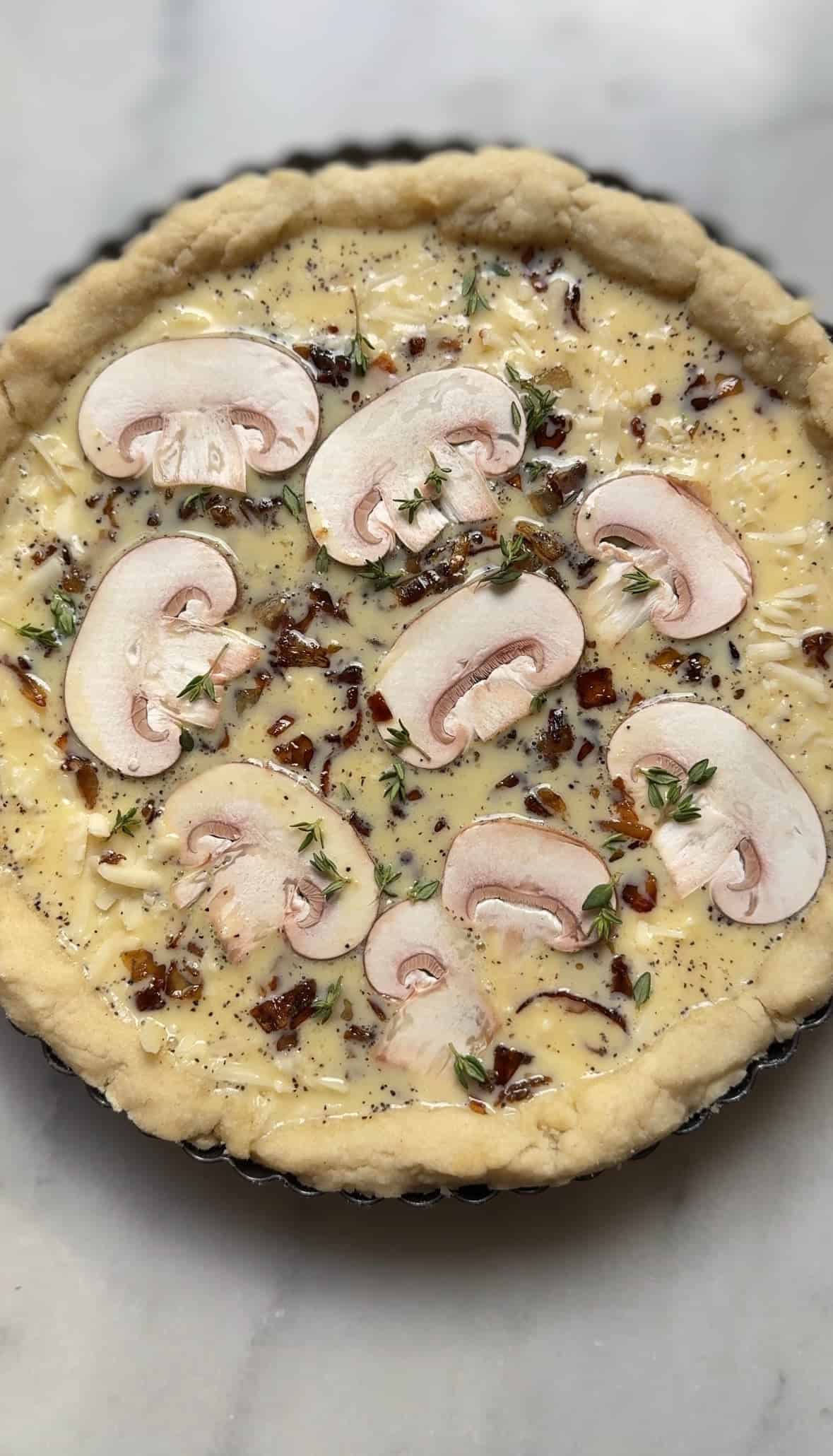 Add the mushrooms and thyme to the egg custard in the par-baked pie crust.