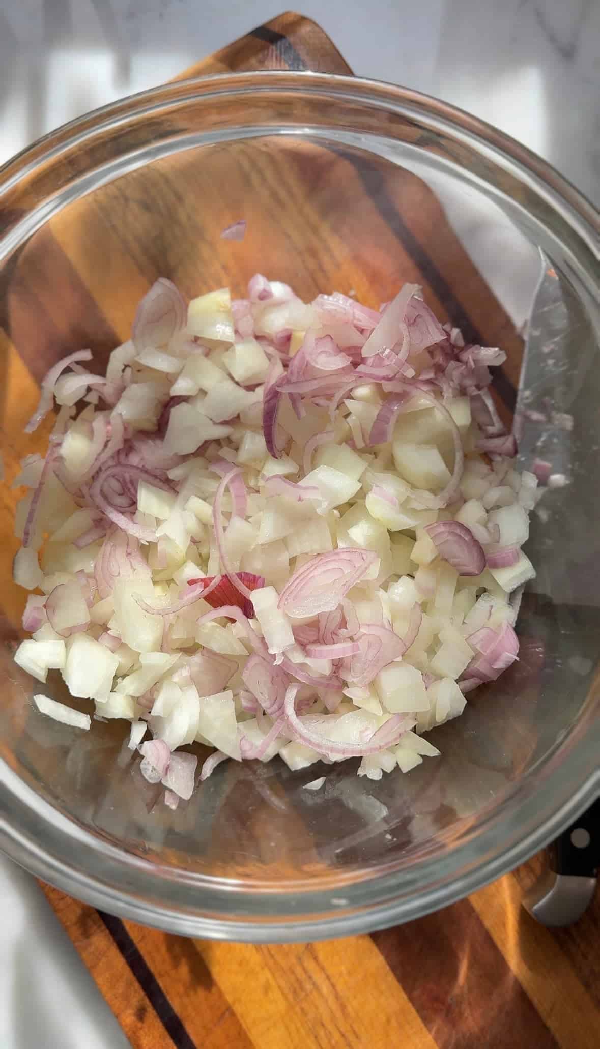 Add the cut up yellow onions and shallot in a bowl.