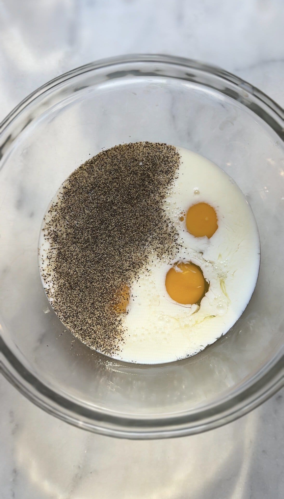 Add pepper to the bowl with the eggs and milk.
