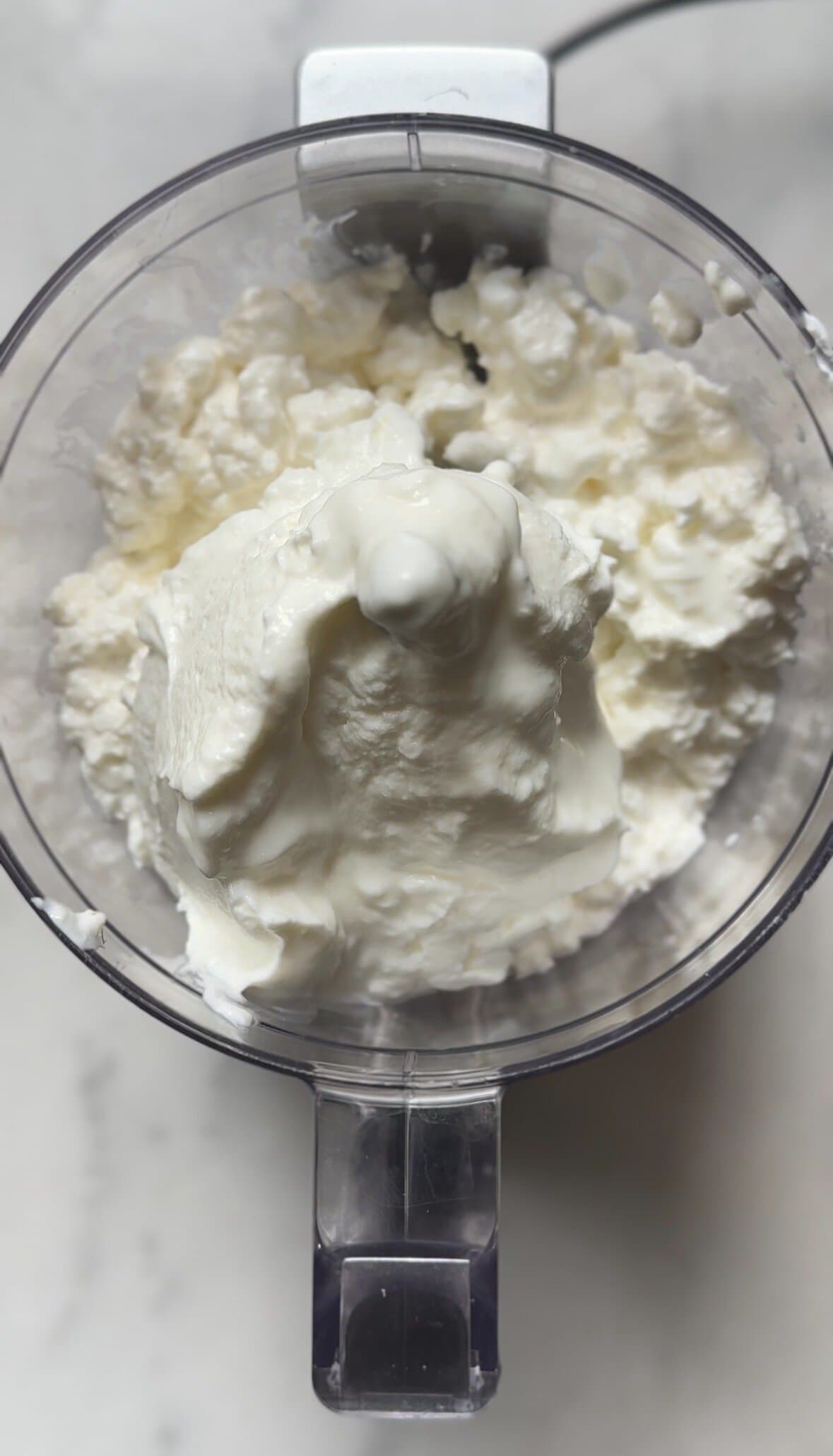 Add cottage cheese and greek yogurt in the food processor.