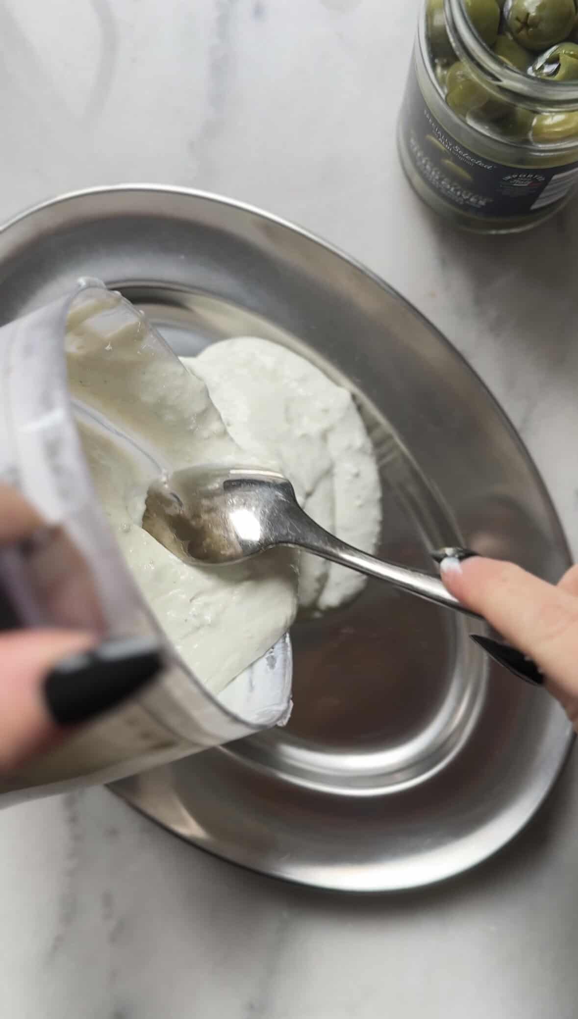 Pour the protein dirty martini dip from the food processor into the serving bowl or plate of choice.