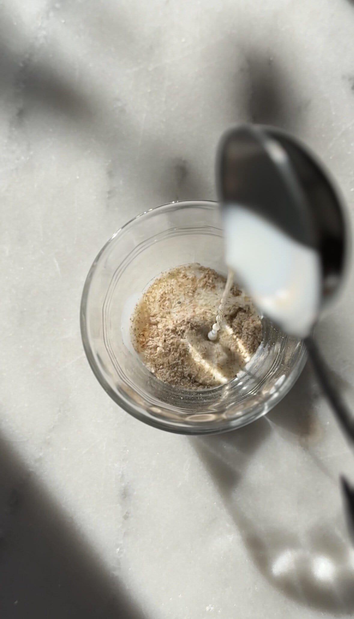 Adding milk to the psyllium husk into a small bowl.