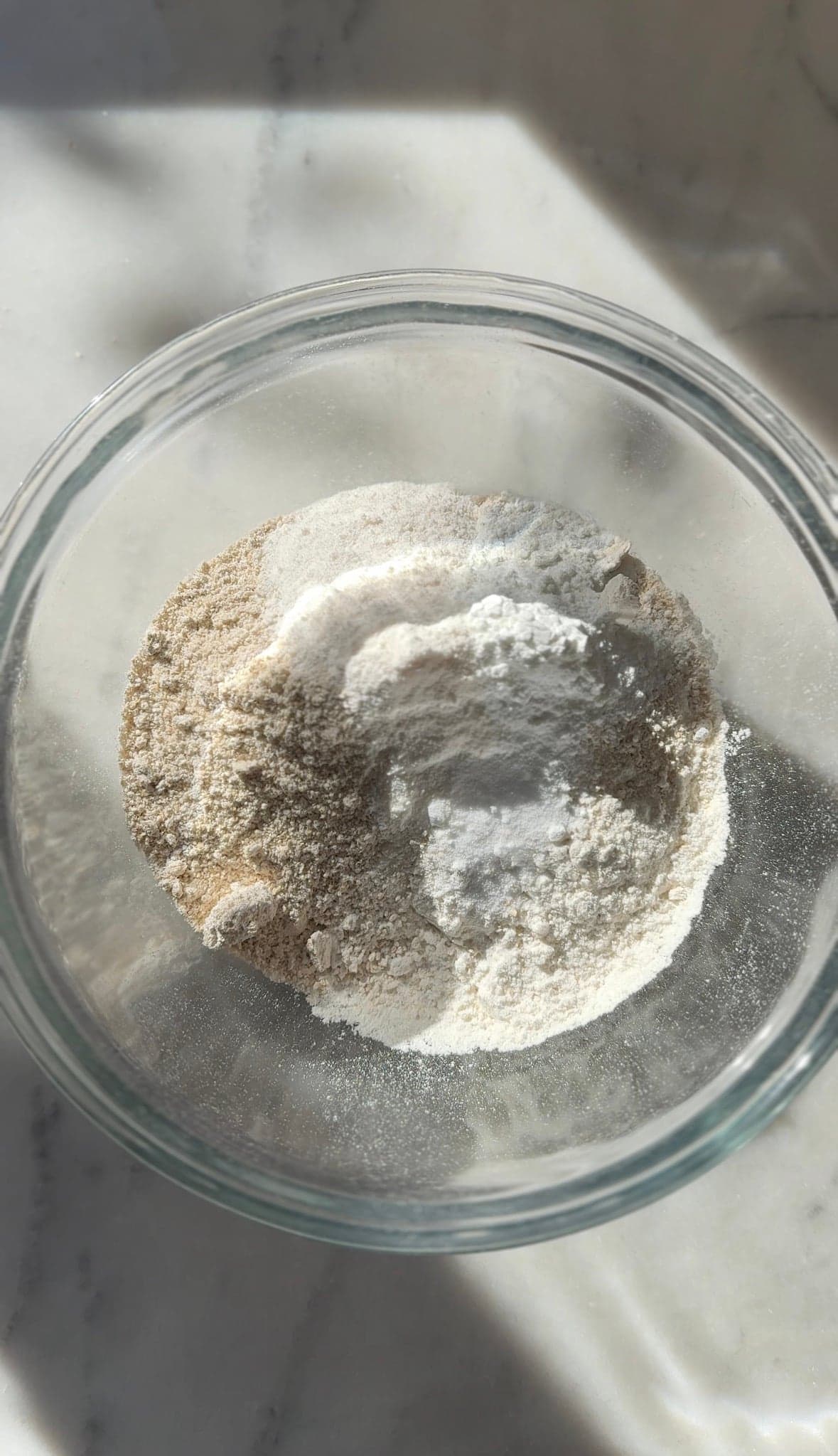 Adding the dry ingredients of the gluten-free cinnamon rolls in a bowl.