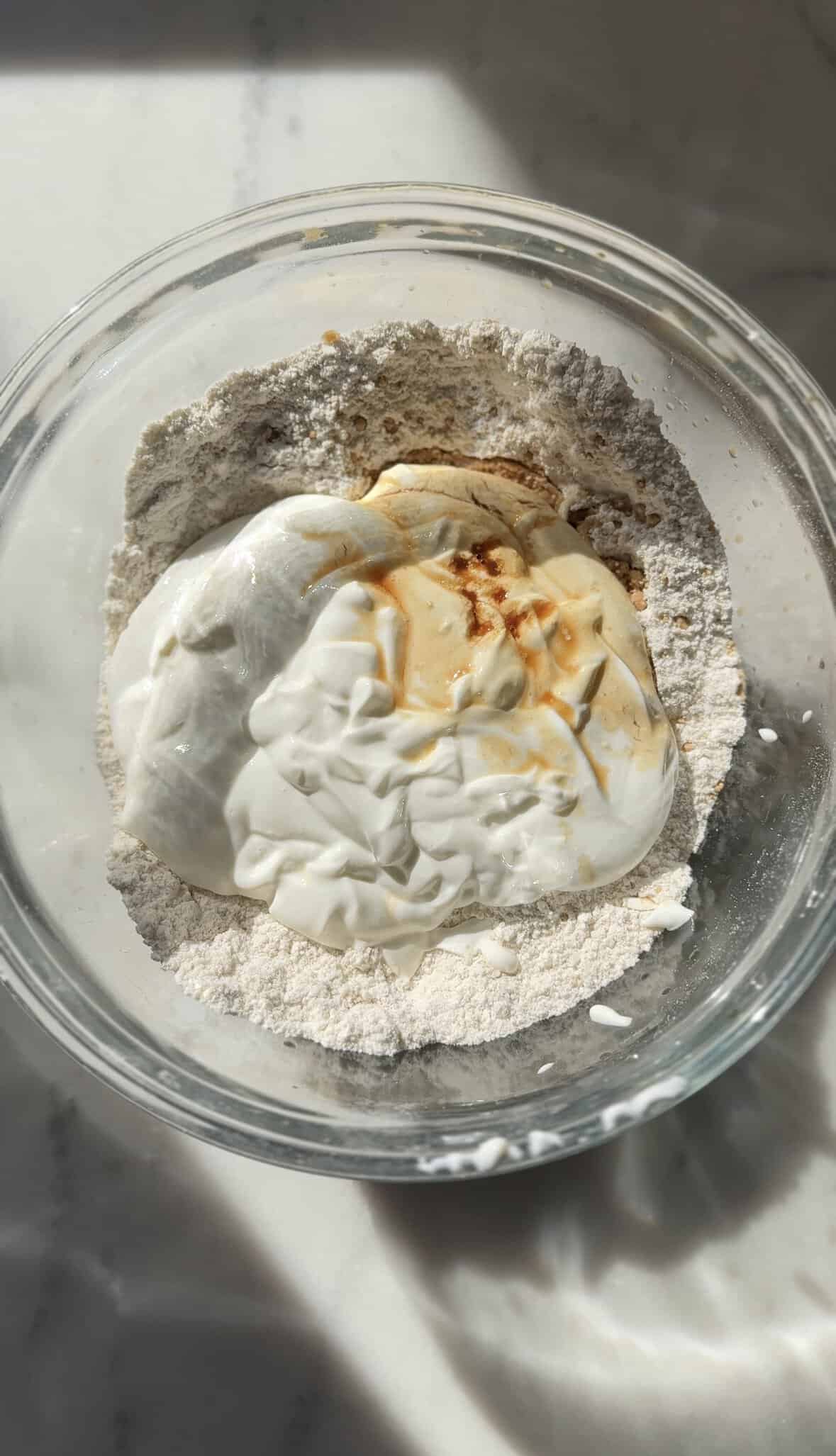 Add vanilla to the gluten-free cinnamon roll dough in the bowl.
