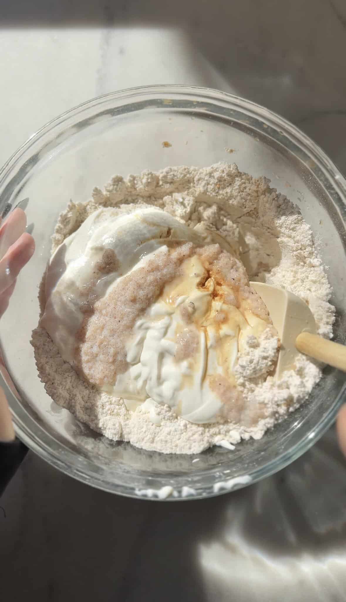Mix the dry and wet ingredients of the gluten-free cinnamon roll dough in the bowl.