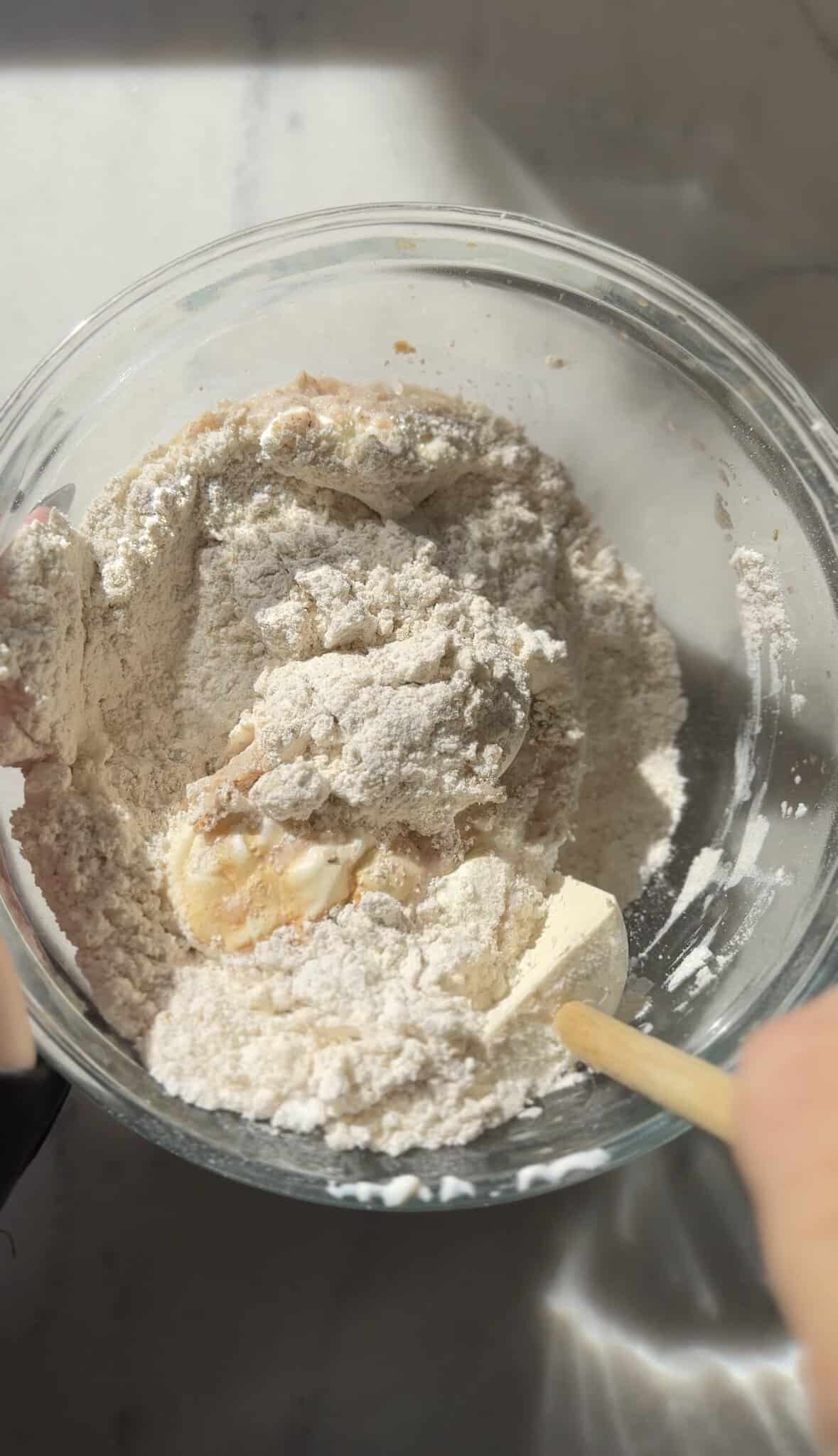 Mix the dry and wet ingredients of the gluten-free cinnamon roll dough in the bowl with rubber spatula.