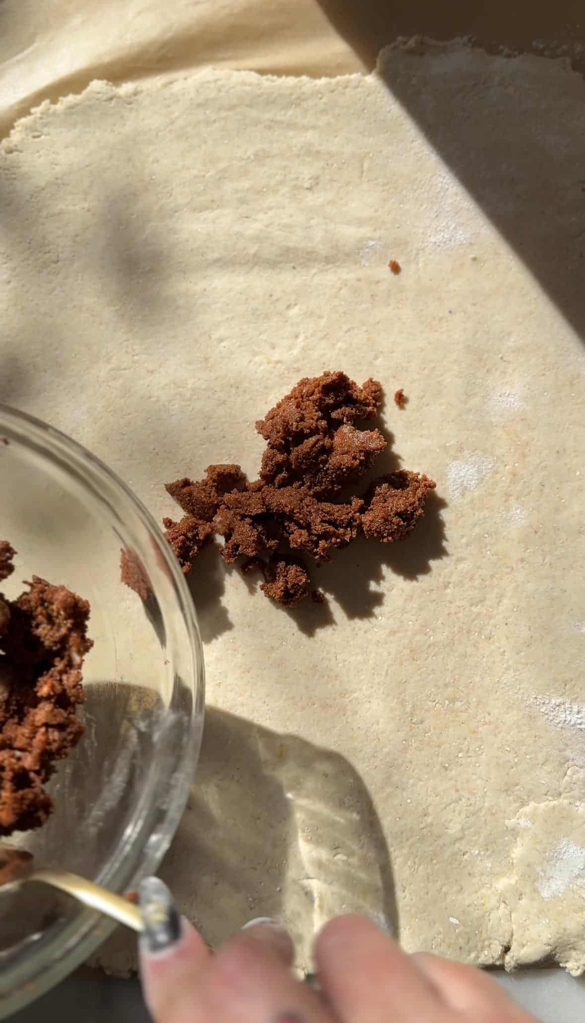 Add the cinnamon sugar filling onto the rolled out cinnamon roll dough.