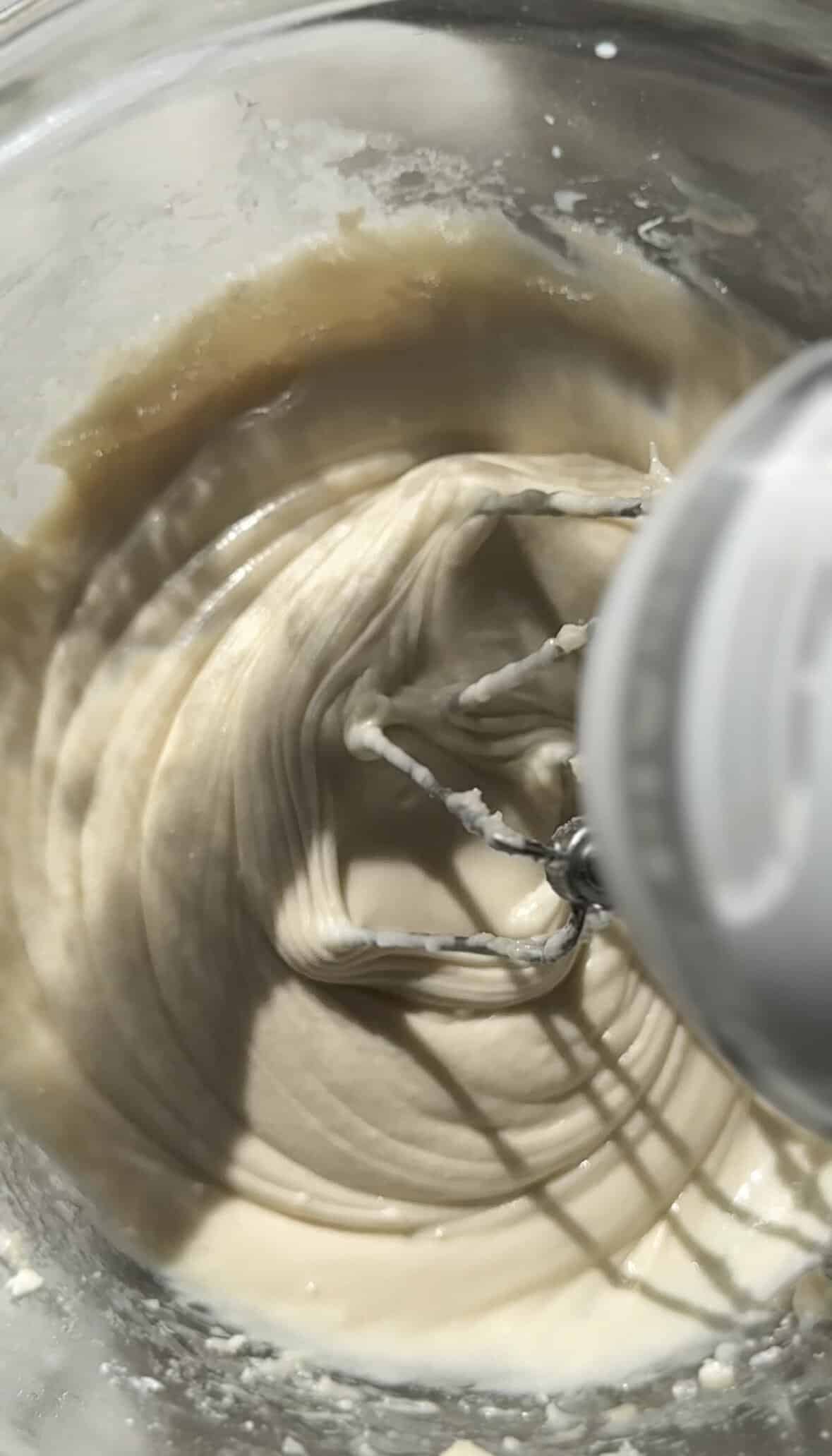 Mixing the ingredients of the cream cheese frosting in a bowl.