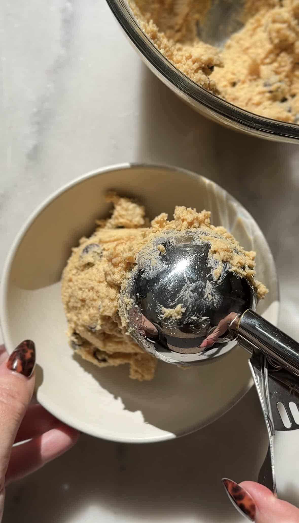 Scooping a serving of the Pumpkin Cottage Cheese Cookie Dough in a bowl to be eaten immediately.